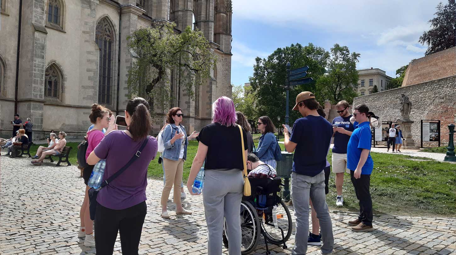 Students gathered outside of St. Vitus Cathedral in Prague as their professor lectures